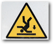 A warning sign: Triangular, black on yellow background, person upside down with downwards arrow
